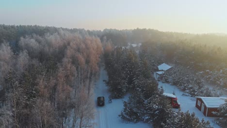 Toma-Aérea-Después-De-La-Conducción-De-Un-Automóvil-En-Un-Bosque-Nevado