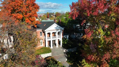 luxurious historic home with white columns and colorful trees