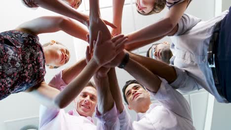 Portrait of smiling executives colleagues with their hands stacked