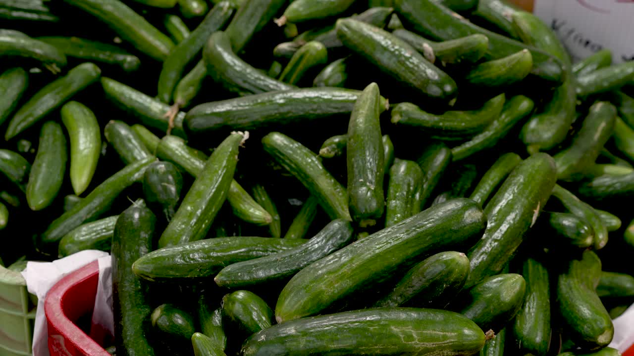 A lively market presents a bountiful display of freshly harvested cucumbers, highlighting the vibrant colors and textures of local produce while showcasing community agriculture at its best