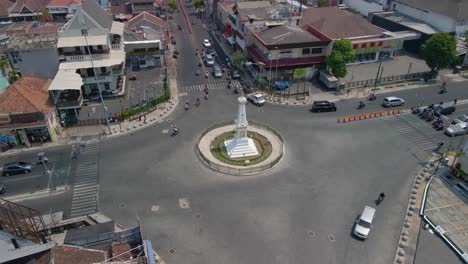 city of yogyakarta and tugu monument in middle of roundabout with traffic, aerial view