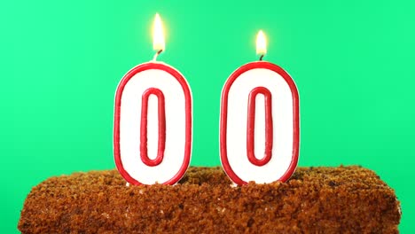 cake with the number 00 lighted candle. chroma key. green screen. isolated