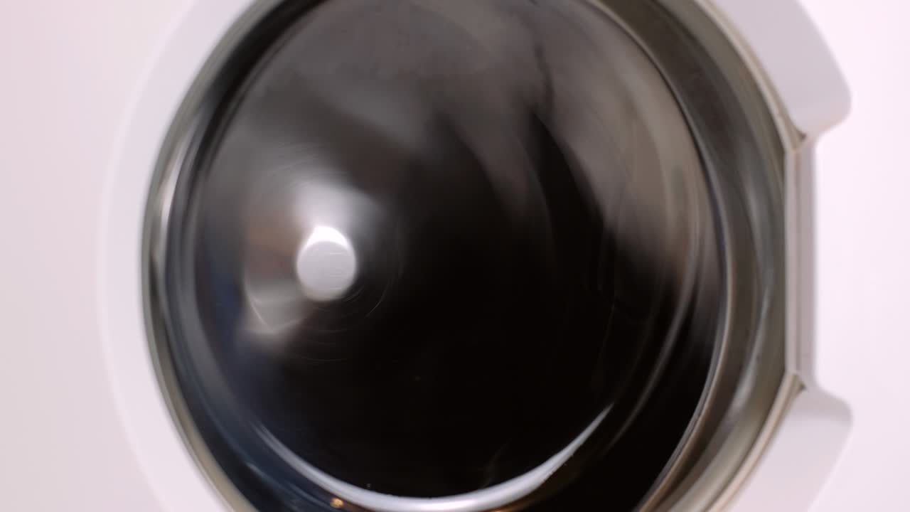 Washing machine washes different clothing and sheets. Cylinder spinning. Nobody
