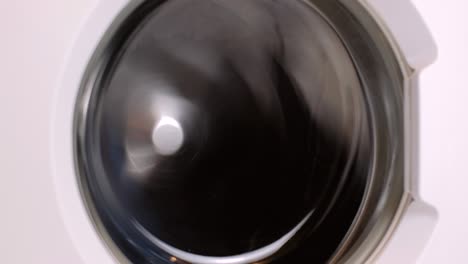 washing machine washes different clothing and sheets. cylinder spinning. nobody