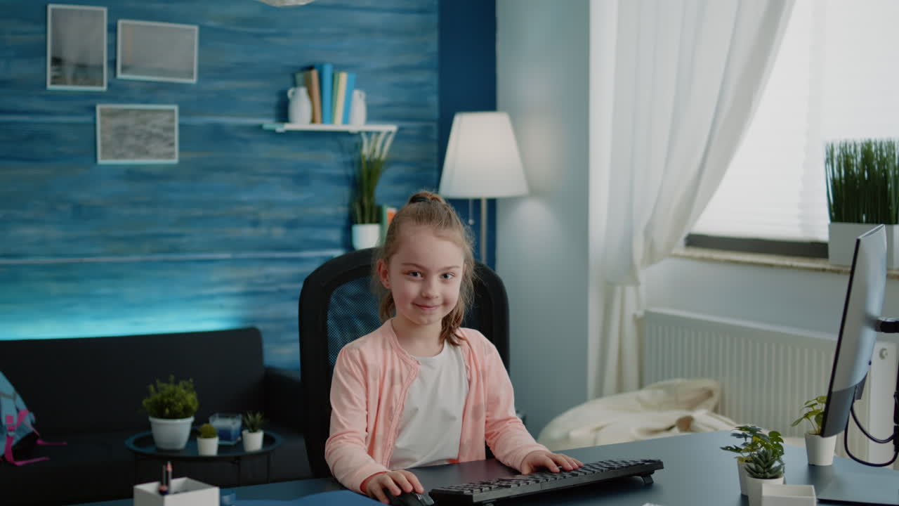 Portrait of child sitting at desk with computer for online lessons