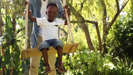 little boy swinging with his father