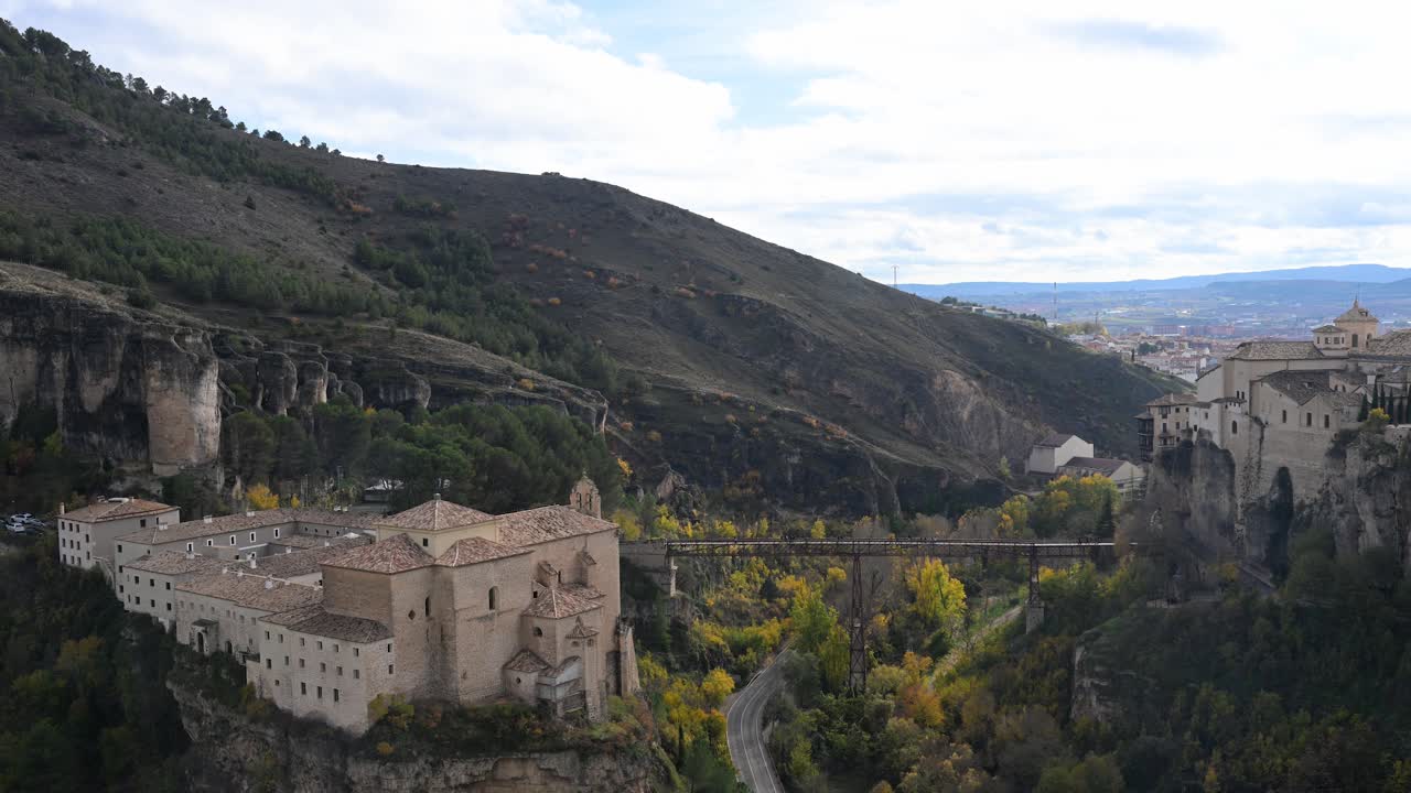 The iron San Pablo Bridge provides a stunning viewpoint of the historic city of Cuenca, Spain, connecting the Parador hotel to the iconic Hanging Houses.