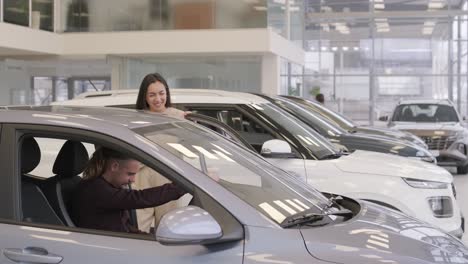 beautiful young couple at car showroom choosing a new car to buy.