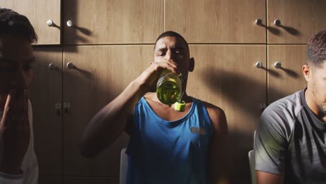jugador de fútbol bebiendo agua en el vestuario