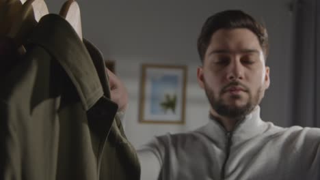 young man at home choosing business suit from wardrobe for job interview 2