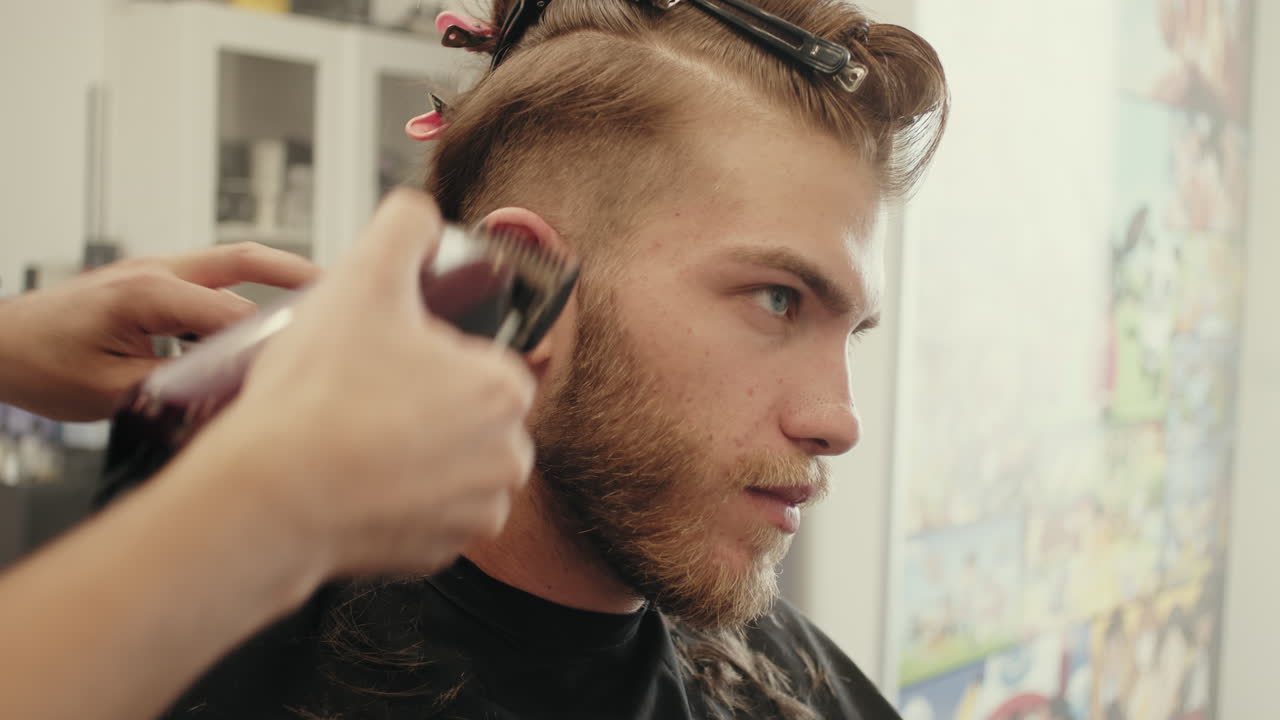 cortando el cabello largo de un hombre en el barbero
