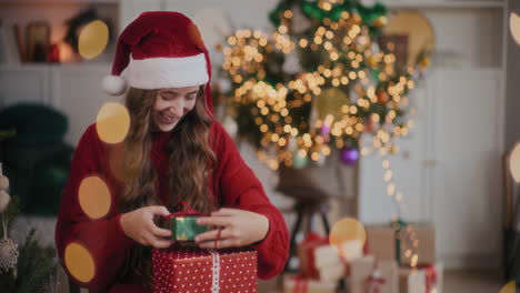 excited woman in santa hat catching gift boxes at decorated home