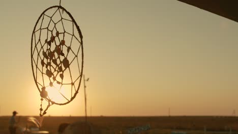 native american dreamcatcher hanging in breeze at sunset