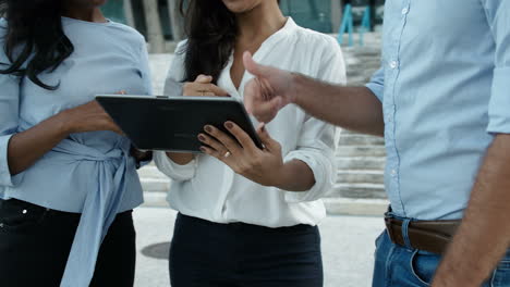 person holding tablet pc and showing project idea to colleagues