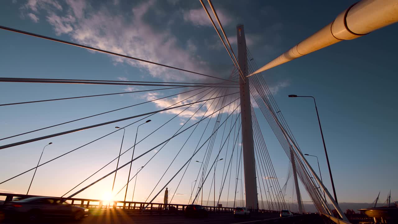 따뜻한 저녁 해가 지는 광선 속에 있는 큰 케이블 스탠드 브릿지