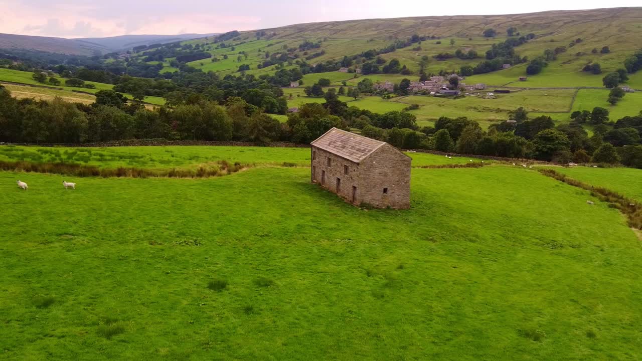 toma aérea de rotación lenta de un granero aislado en el valle de yorkshire dales