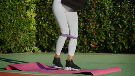 woman doing leg workout with resistance band outdoors