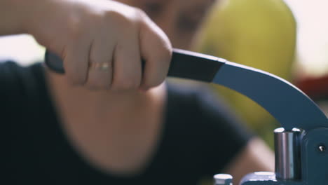 el sastre profesional fija los accesorios con la máquina de prensa