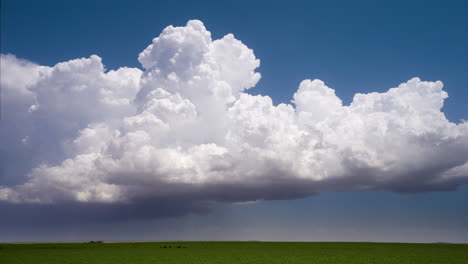 massive cumulus clouds over a green field
