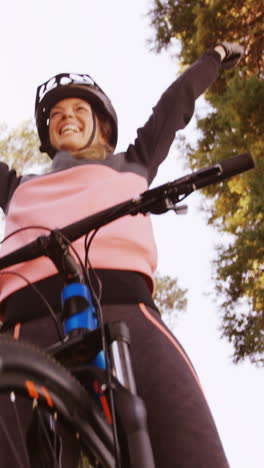 motociclista de montaña excitada con los brazos extendidos