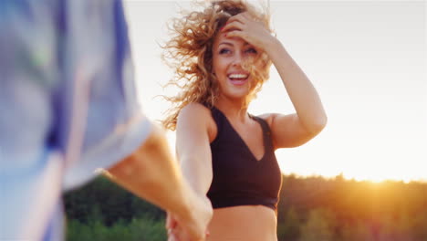 Follow-Me-Young-Attractive-Woman-Carries-Her-Partner\'s-Hand-Leading-Him-On-A-Sunset