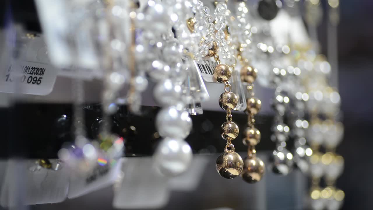 красивые жемчужные ожерелья со сверкающими драгоценными камнями в магазине, крупным планом в фокусе стойки