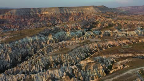 Cappadocia-landscape-with-tuff-stone-formations-after-sunrise,-backwards-aerial