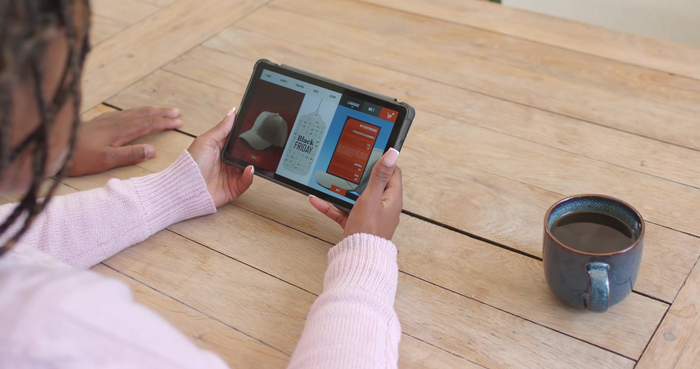 Tablet is receiving finger touch and is scrolling product page on wooden table to view options