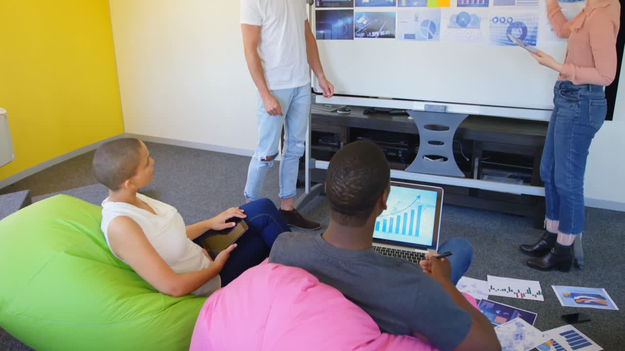 joven equipo de negocios de raza mixta planeando y sentado en una oficina moderna 4k