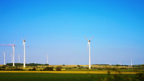 turbines produce clean energy. wind turbines stand tall against the clear blue sky, producing renewable energy in a serene countryside setting