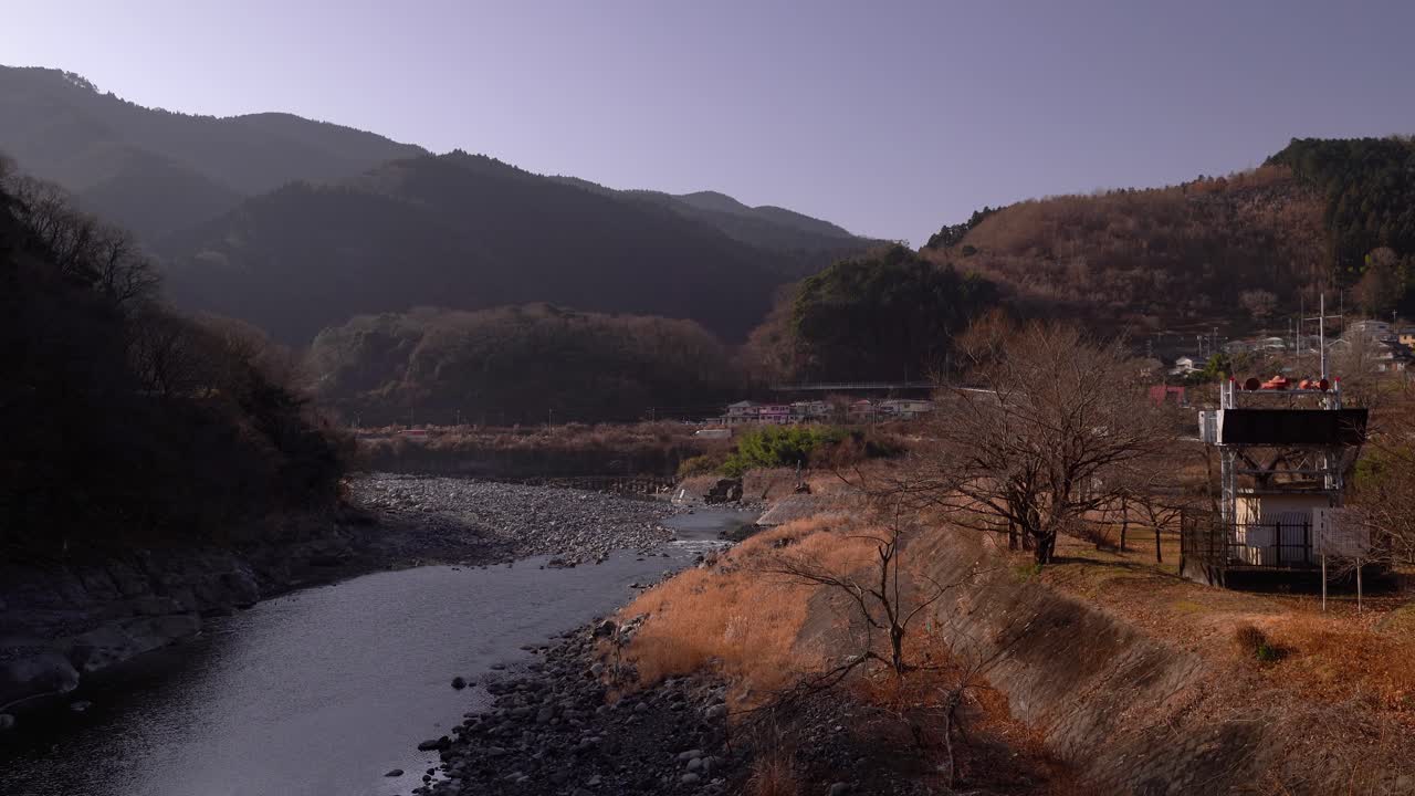 hermoso valle inundado por el sol con siluetas de montaña y río corriente