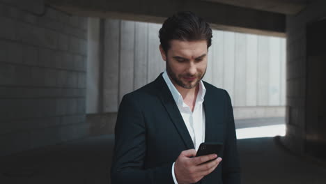 businessman texting message on cellphone outdoors. man using smartphone in city