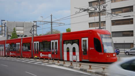 red tram moving through city streets