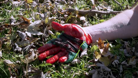 Bleeding-hand-with-Improvised-Tourniquet-made-of-fabric,-lying-on-a-grass,-Close-up