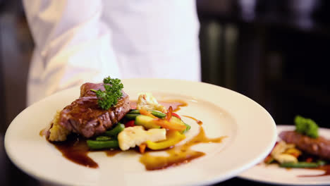 happy chef showing beef dish