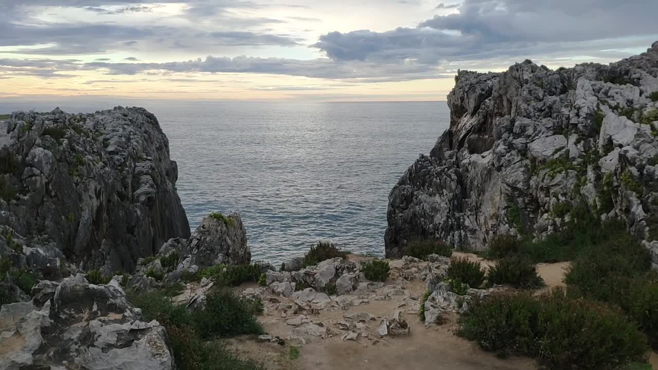 Rocky cliffs meet calm sea at sunset, Guadamia and Tuzarrizu, Asturias, Spain