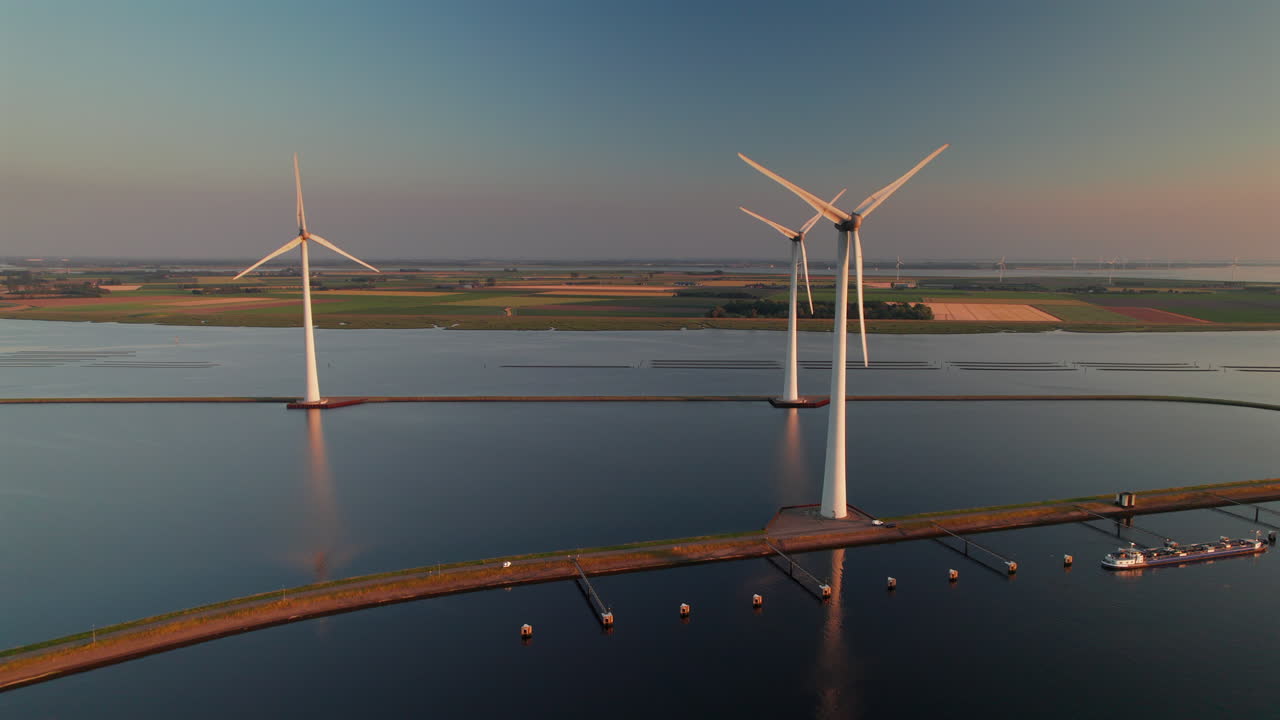 Wind Turbines At Krammer Lake Spinning During The Golden Hour In Bruinisse, Netherlands. - aerial shot