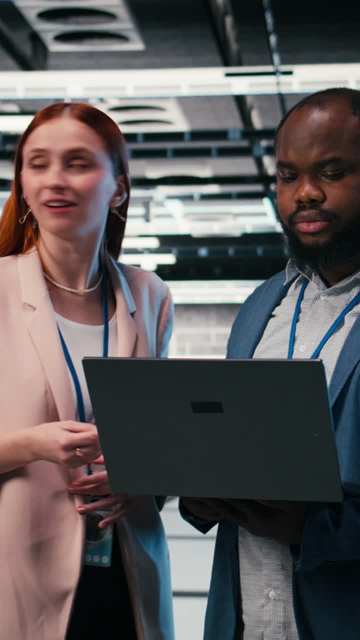 Vertical video Optimizing electronics, laptop and manager teaching intern in server farm