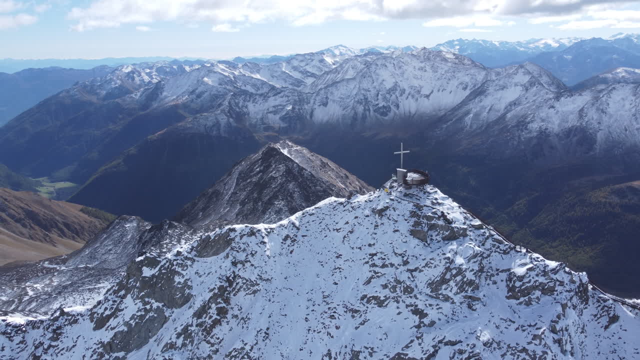 tiro de arco aéreo de una cruz en la cima del pico otzi del hombre de hielo, un impresionante punto panorámico rodeado por las pintorescas montañas nevadas del glaciar val senales, tirol, italia
