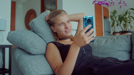 woman relaxing on couch, using smartphone