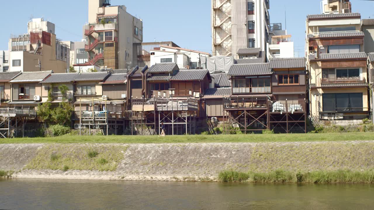 casas abarrotadas junto a un río en kyoto, japón cámara lenta 4k
