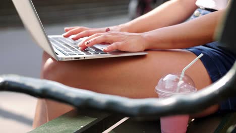 la mano de la mujer escribiendo en la computadora portátil
