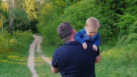 un padre joven y saludable camina con su hijo en el parque
