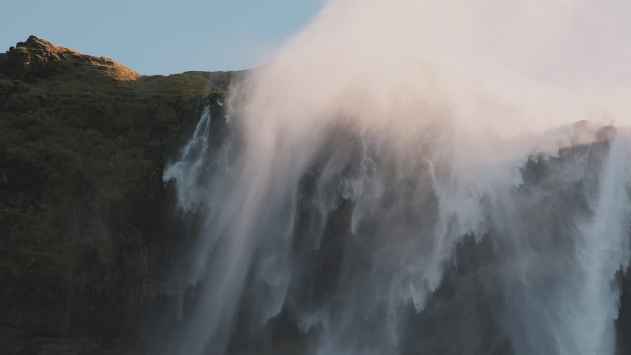 la niebla de un gran ciclón en cascada se arremolina y sopla alrededor de un acantilado escarpado, islandia