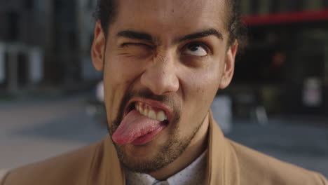 portrait of young attractive mixed race man making faces looking at camera funny crazy