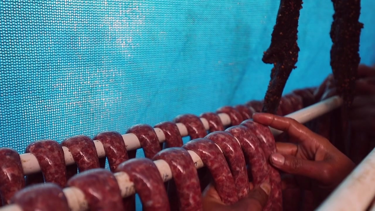 Longa corda de linguiça Droewors crua é pendurada em um suporte de secagem na África do Sul.