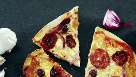pizza italiana en una mesa de madera con verduras y especias
