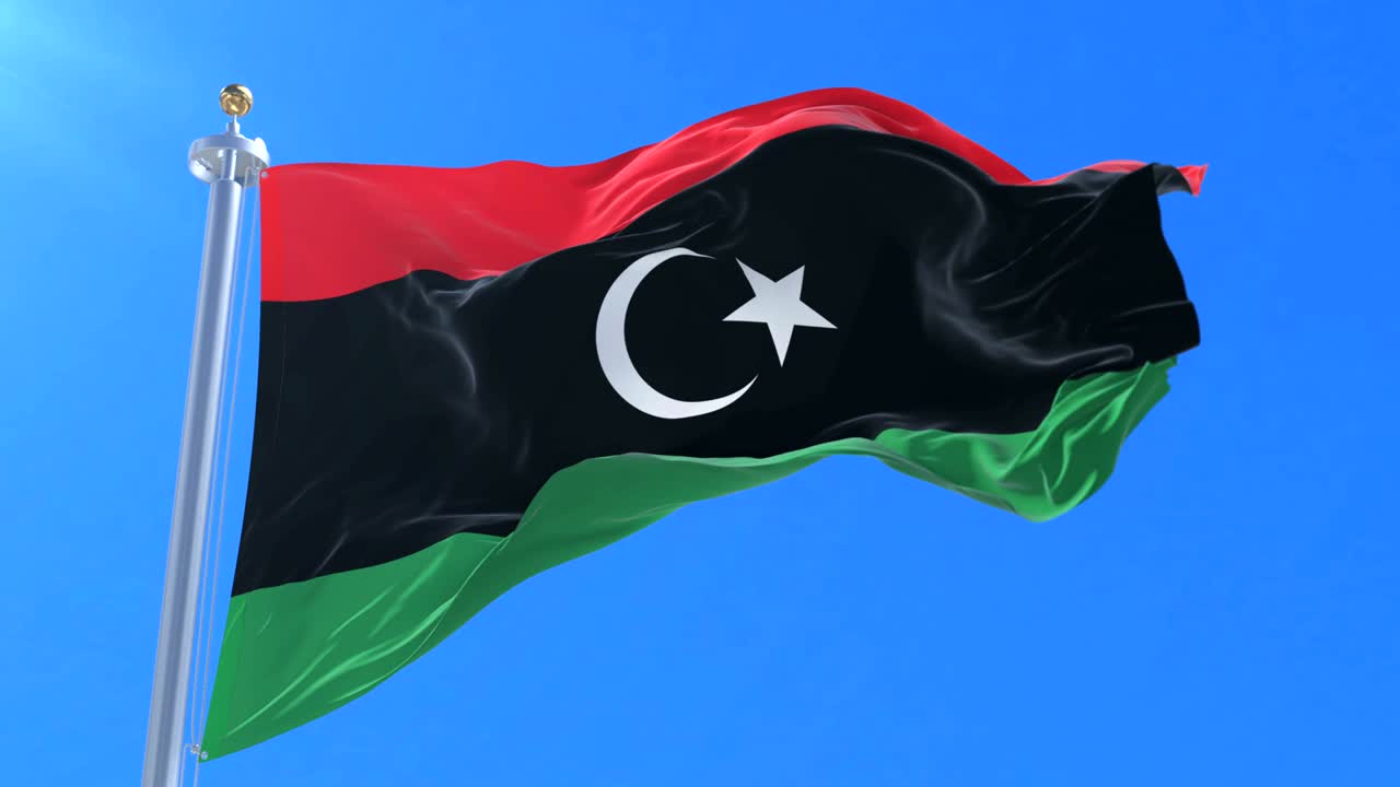 Bandera de Libia ondeando al viento con cielo azul en cámara lenta, en bucle.