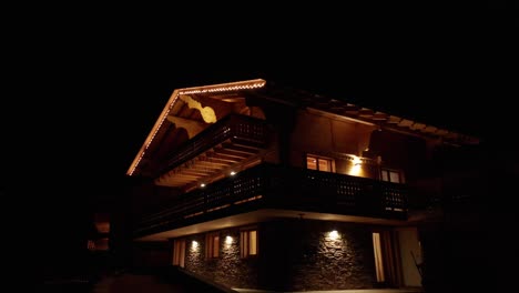 Jib-up-of-beautiful-chalet-with-lights-on-at-night