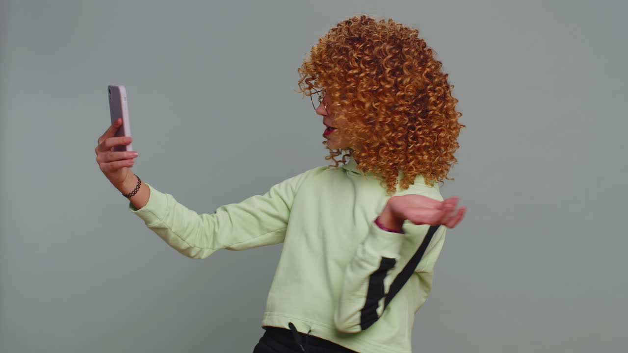 Child girl kid blogger taking selfie on smartphone communicating video call online with subscribers